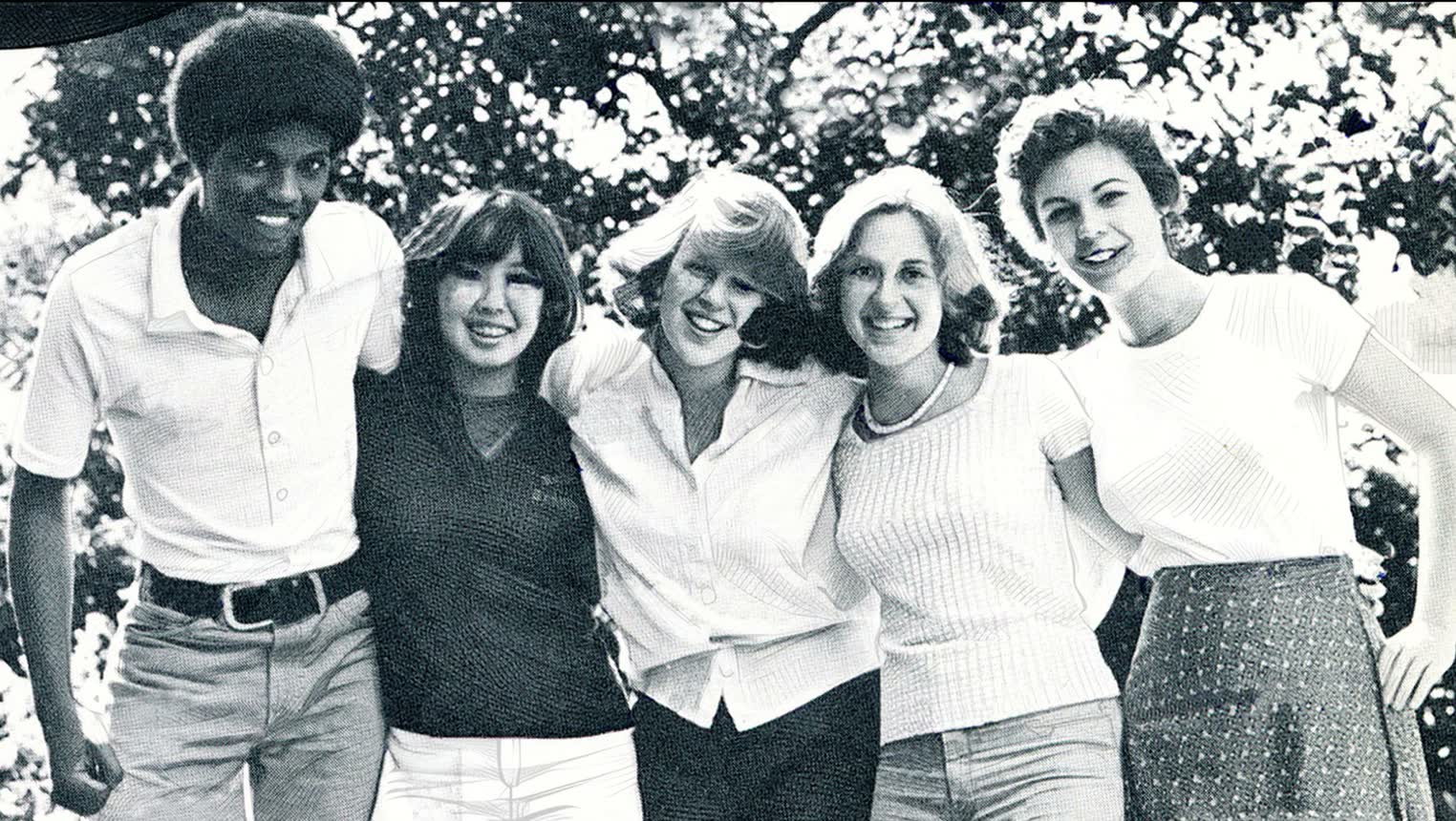 A full-screen yearbook candid from the film: five friends with their arms around each other, in a white photo border.